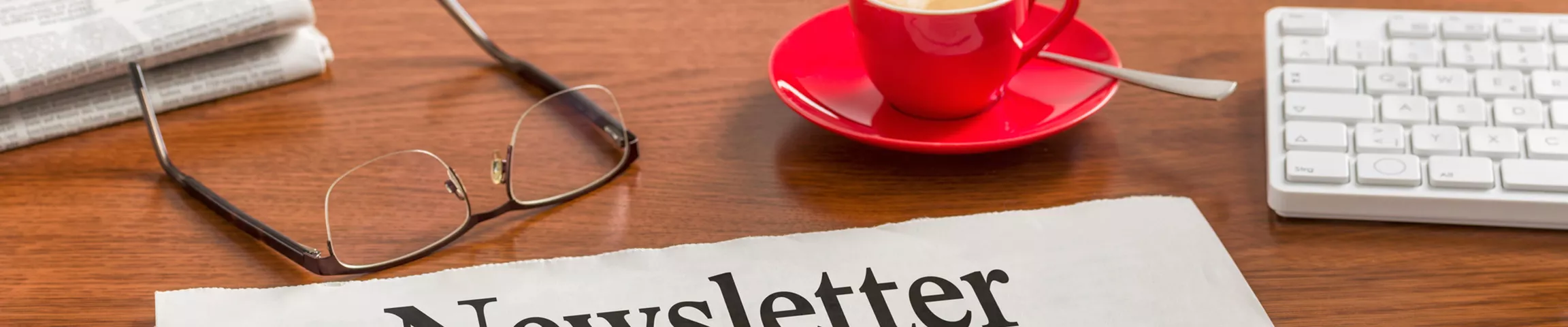 Caffee, glasses, keyboard and newsletter