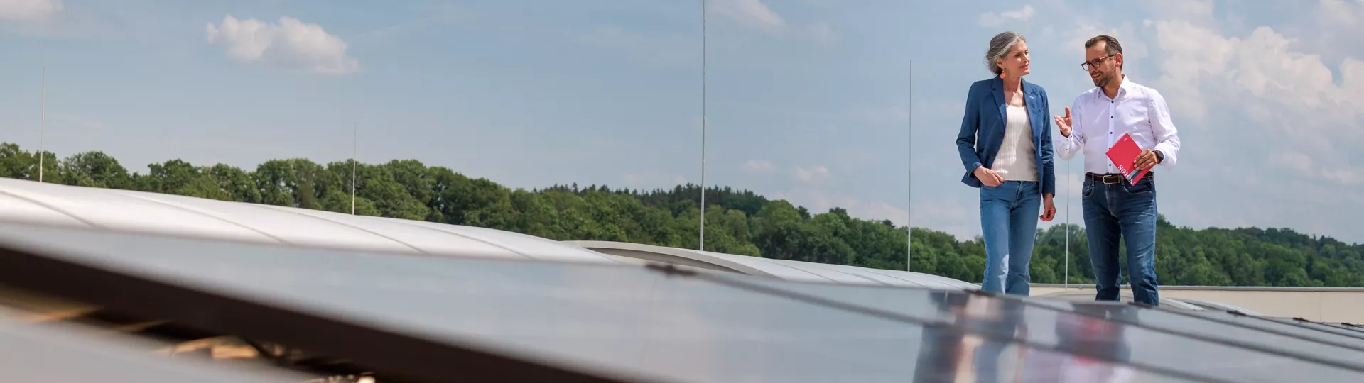 Customer and installer on roof in front of pv modules