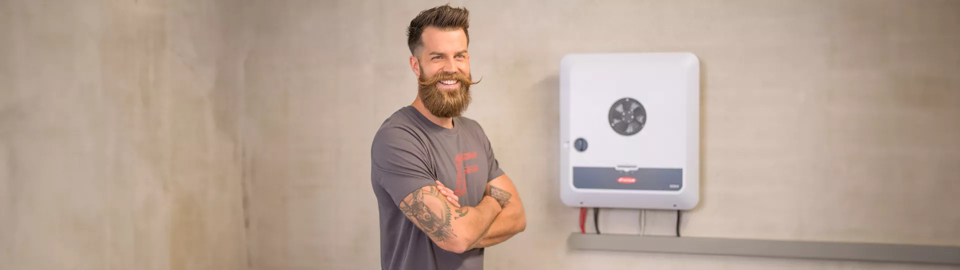 Installer in front of GEN24 inverter on the wall