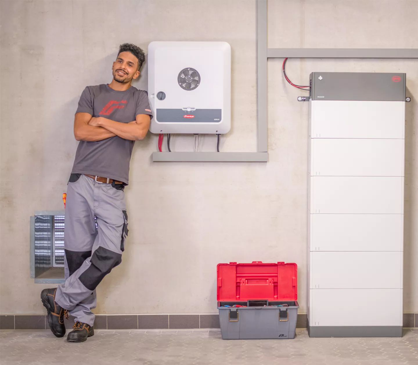 Installer next to GEN24 inverter and storage battery